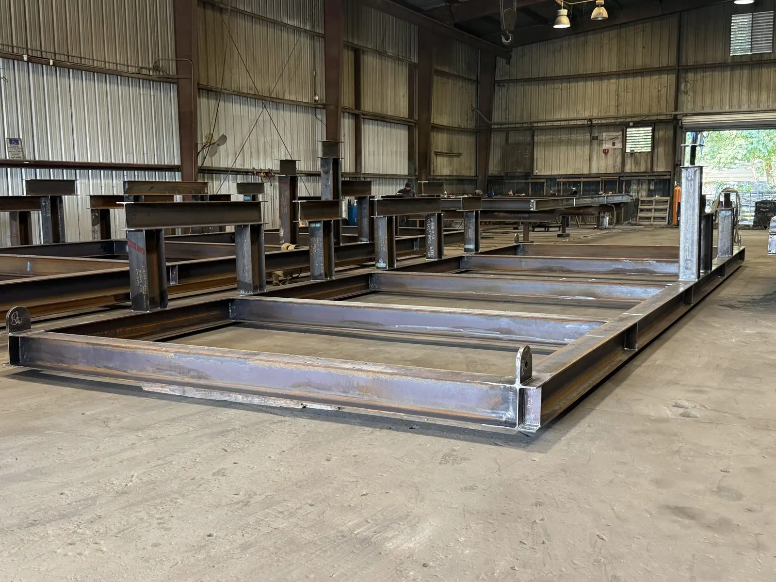 Welded steel frame on the shop floor with beams behind